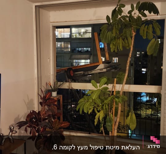 מנוף בנייה מחוץ לחלון עם תאורה לילית